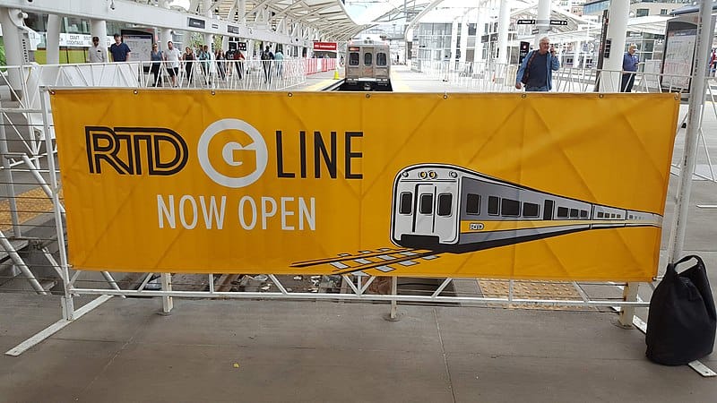 Now Open Banner for a public train attached to a fence