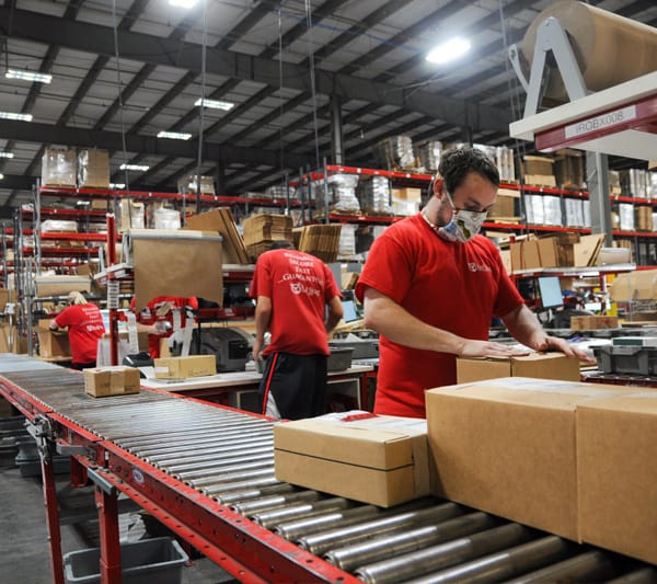 Multiple people working at packing boxes