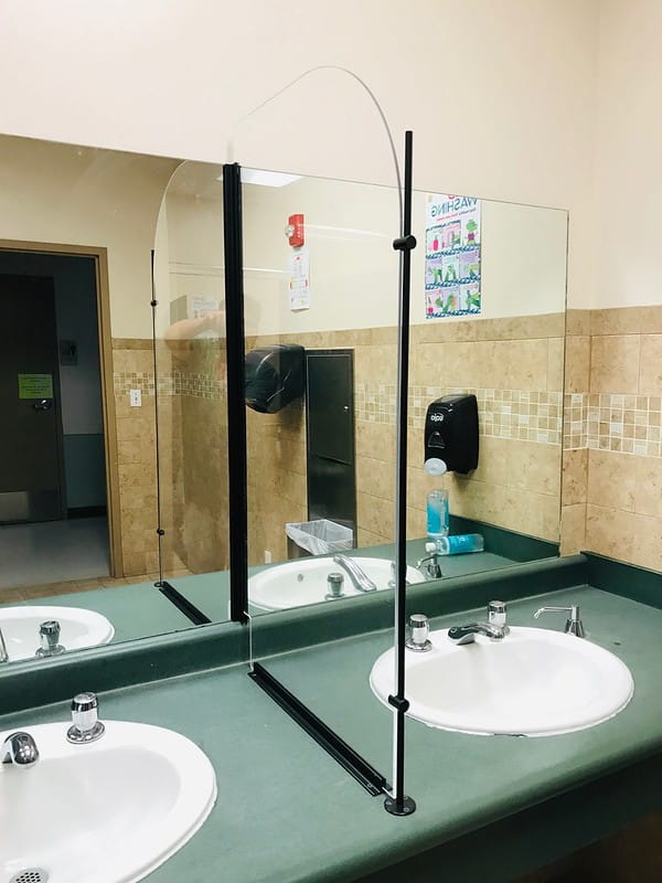 Glass inset separator in between sinks in a public bathroom