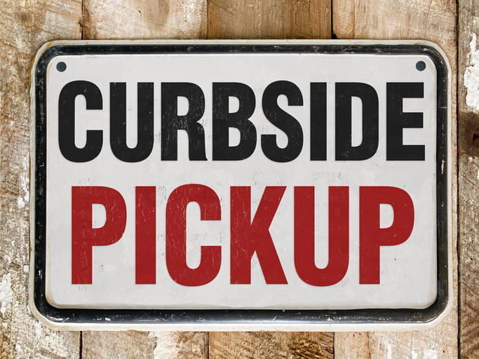 Curbside Pickup Sign bolted to a fence